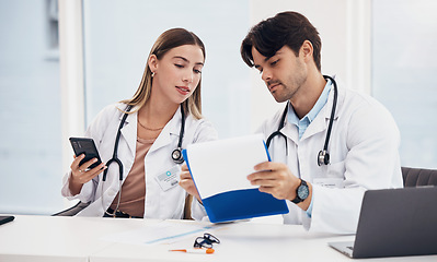 Image showing Doctors, healthcare and working together with clipboard for planning, research and medical schedule at desk in hospital. Medicine, man and woman with collaboration, teamwork or brainstorming results