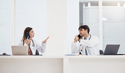 Image showing Doctors, phone call and healthcare at reception desk for communication, networking and medical schedule in hospital. Medicine, man or woman with laptop for collaboration, teamwork or conversation