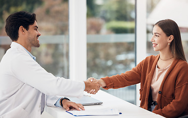 Image showing Doctor, woman and handshake or welcome at hospital reception or help desk for healthcare support and thank you. Medical worker shaking hands with young patient for advice, help or clinic registration
