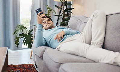 Image showing Man, phone and relax on sofa for social media, communication or entertainment in living room at home. Male person lying on lounge couch with mobile smartphone for online app or streaming at house