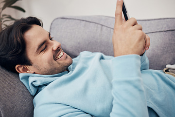 Image showing Happy man, phone and relax on sofa for social media, communication or networking in living room at home. Male person smile and enjoying online chat on mobile smartphone app on lounge couch at house