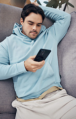 Image showing Man, phone and relax on sofa for social media, communication or networking in living room at home. Male person lying on lounge couch for online chatting or texting on mobile smartphone app at house