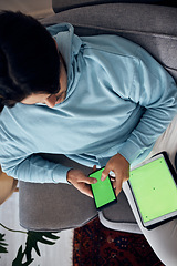 Image showing Phone, green screen and a man playing games on a sofa in the living room of his home from above. Tablet, gaming and young gamer using a display or screen with tracking markers for entertainment