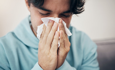 Image showing Man, sick and couch with tissue, sickness and virus for infection, sinus and cold symptoms. Sneeze, blowing nose and allergy in living room sofa, hayfever and healthcare for disease, fever or alone