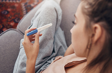 Image showing Pregnancy test, waiting and woman on sofa in home, reading news and check results.,Stick, sad and pregnant mother in living room for future maternity, ivf fertility and anxiety, depressed or serious