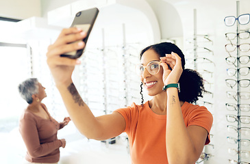 Image showing Selfie, optometry and woman trying glasses with prescription lenses and frame in an optical store. Vision, smile and young female person taking a picture on a phone for choosing spectacles in clinic.