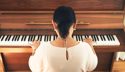 Image showing Musician, piano and person playing music in home living room for artistic musical and creativity talent learning. Back view, lounge and artist practice song on keyboard as hobby with instrument