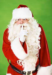 Image showing Santa claus, finger and quiet secret in studio for Christmas surprise, celebration or holiday excitement. Male person, hand gesture and hush emoji for winter vacation joy, green background or mockup