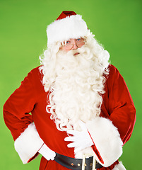 Image showing Santa claus, serious and portrait in studio for Christmas season, joy celebration or winter holiday. Male person, tired and face or red outfit on green background as mockup, festive fun or vacation