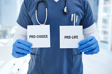 Image showing Closeup, doctor and abortion with option, card and healthcare in a hospital, policy and law. Zoom, person and medical professional with poster, choice and paper with nurse and decision in a clinic