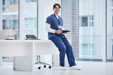 Image showing Hospital portrait, tablet and happy man, doctor or relax nurse research, typing or search medical database, info or data. Online medicine stats, healthcare clinic and surgeon sitting on office desk