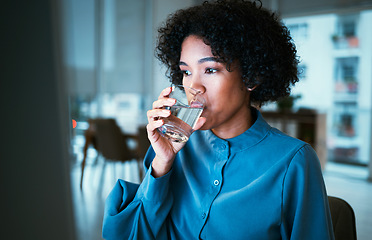 Image showing Woman, drinking water and night in office, reading or thinking for hydration, wellness or finance company. Accountant, glass and computer for nutrition, diet or detox for health, idea or workplace