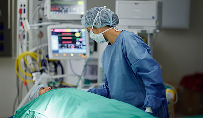 Image showing Bed, theatre or doctor with patient in surgery procedure or healthcare operation in hospital clinic. Accident injury, people or surgeon in face mask helping in operating room in medical at night