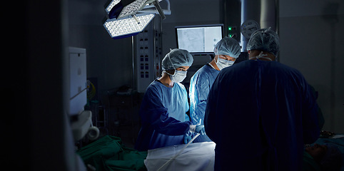 Image showing Surgery, dark room and doctors with healthcare, teamwork and support with wellness, safety and emergency. People, medical professionals or group with cooperation, theatre and medicine in hospital