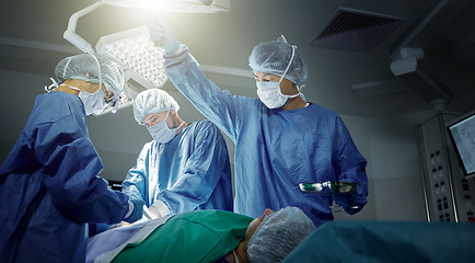 Image showing Teamwork, healthcare and surgeons working on a surgery for medical treatment in a theatre room. Collaboration, career and professional doctors doing an operation on a patient in a hospital or clinic.