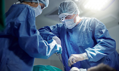 Image showing Healthcare, teamwork and doctors in a hospital for surgery together, working in theater to save a life. Medical, emergency and a surgeon team in the operating room of a clinic for an operation