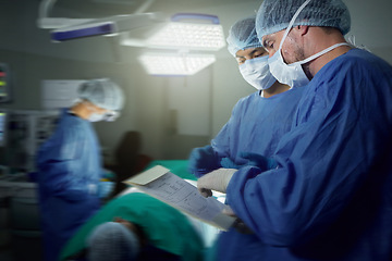 Image showing Healthcare, surgeon and a team in a hospital for surgery together, working in theater to save a life. Medical teamwork, emergency and doctors in the operating room of a clinic for an operation