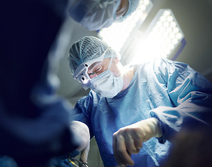 Image showing Healthcare, teamwork and doctors in theater for surgery together, working in a clinic to save a life. Medical, emergency and a surgeon team in the operating room of a hospital for an operation