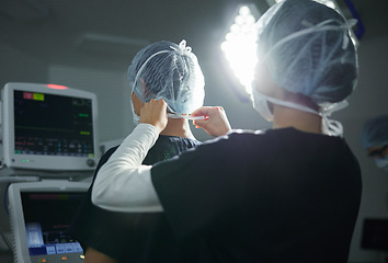 Image showing Getting ready, healthcare and doctors in a surgery theater for medical procedure or treatment. Help, clothing and surgeons with hair nets at a hospital for a clean operation or teamwork in medicine