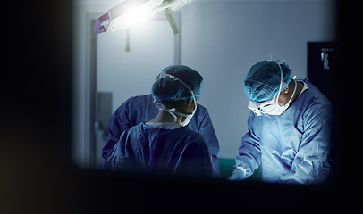 Image showing Teamwork, emergency and doctors in a hospital for surgery together, working in theater to save a life. Medical, healthcare and a surgeon team in the operating room of a clinic for an operation