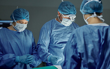 Image showing Teamwork, healthcare and doctors working on an operation for medical treatment in a theatre room. Collaboration, career and professional surgeons doing a surgery on a patient in a hospital or clinic.