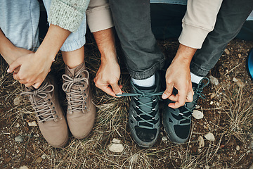 Image showing Shoes, hands tie lace and hiking, people outdoor in nature for travel with adventure top view. Boots, friends camping with start or prepare for walk, trekking and journey with health and fitness