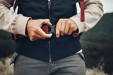 Image showing Closeup hands, man and nature fastening a backpack for hiking, trekking or travel in the mountains. Walking, buckle clip and a tourist with a bag in the woods for activity, fitness and exercise