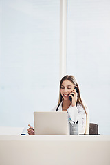 Image showing Female doctor, talk and phone with laptop in office for consultation, meeting or healthcare with patient. Medical professional, woman and technology with smile for email, schedule or document on web