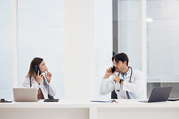 Image showing Doctors, talking and people with phone call in office with confidential, info and gesture to whisper. Medical, nurse and busy with administration and frustrated employees with noise or telehealth