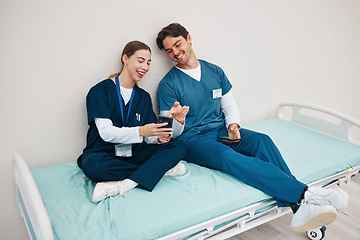 Image showing Doctors, smartphone and break on hospital bed, relax and happy from healthcare service, job and career. Nurse, man and woman for rest, shift and employee for social media, memes and communication