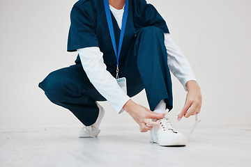 Image showing Healthcare, shoes and tie with hands of a nurse in studio while getting ready for medical service closeup. Medical, lace and dressing with a medicine professional in uniform at a clinic for nursing