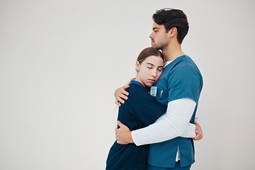 Image showing Doctor, colleagues and tired stress for support, healthcare clinic or hug. Medical professionals, friends and helping comfort in scrubs on wall background, mockup space or fatigue trust at hospital