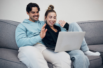 Image showing Couple, video call and wave on laptop in living room with communication for family. Young man, woman and together in happiness, embrace or love in relationship on sofa with technology, web or app