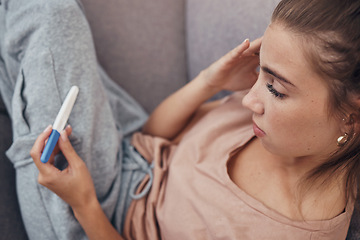 Image showing Pregnancy test, sad and woman on sofa in home, reading bad news or negative results. Stick, serious and frustrated pregnant mother depressed in living room for fail, stress or anxiety for infertility