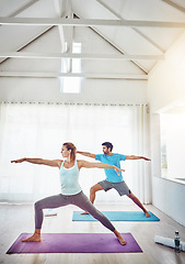 Image showing Couple, yoga and stretching in studio workout, exercise and holistic training with balance, pilates or fitness. People or personal trainer in warrior pose for wellness, health and learning together