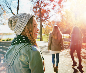 Image showing Teenage girl in nature with friends, walk in park with autumn and sunshine, wellness with happiness. Youth outdoor, enjoy fresh air and bonding with smile, lens flare with adventure or travel