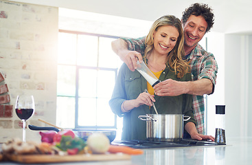 Image showing Love, recipe and salt with a couple cooking in the kitchen of their home together for health, diet or nutrition. Smile, food or seasoning with a happy mature man and woman in their house for flavor