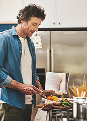 Image showing Recipe, food and man cutting vegetables in the kitchen for diet, healthy or nutrition dinner. Book, cooking and mature male person from Canada chop ingredients for a supper or lunch meal at home.