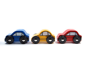 Image showing Three wooden toy cars in a row