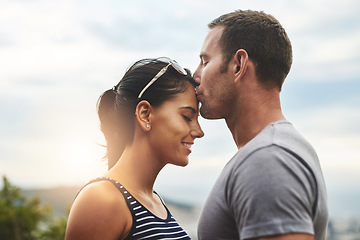 Image showing Forehead, love or couple kiss in nature for date, wellness or care on summer romance or adventure. Peace, smile or man with happy woman on outdoor holiday vacation together to bond, support or relax