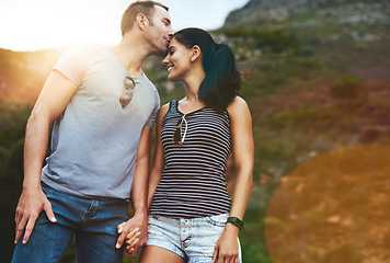 Image showing Mountain, kiss or happy couple holding hands on date with wellness or care for romance or adventure. Bokeh, smile or man with woman on holiday vacation together for bond or support in nature or park