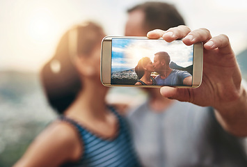 Image showing Phone, selfie and couple kiss in nature outdoor on summer vacation together. Smartphone screen, romance and picture of man and woman in countryside for connection, memory of love and relationship