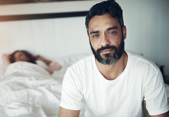 Image showing Sad, depression and portrait of a man on a bed with wife sleeping in the morning. Upset, depressed and a mature male person looking tired, frustrated or unhappy with a woman in the bedroom for sleep