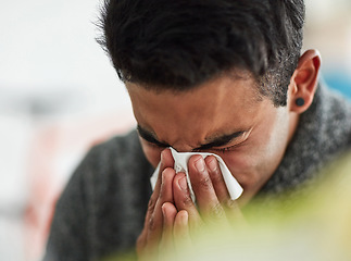 Image showing Sick, hands and blowing nose with a man using a tissue closeup in his home for relief from allergy symptoms. Face, cold or flu and a young person ill with a virus due to bacteria, pollen or hay fever