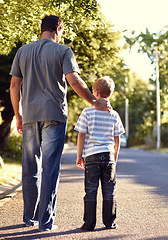 Image showing Back view, father and child walking on street together for bonding, support and love on vacation or holiday in summer. Care, talking and dad on road with kid in neighborhood on weekend as parent