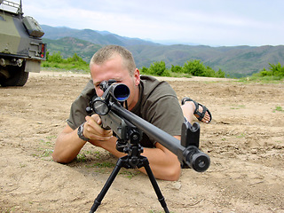 Image showing Soldier, sniper and man with a gun, military and war with a battle, fighting and combat with conflict. Person, warrior and guy on the ground, weapon and shooting at target with army, outdoor and hero