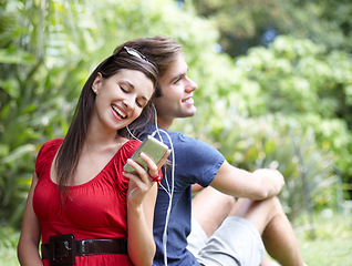 Image showing Happy, love and couple relax in a forest with music, conversation and bonding outdoor. Smile, romance and people in a park for date in nature while chilling on and having fun with weekend freedom