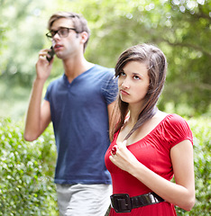 Image showing Couple fight, phone call and woman frustrated by cheating man, liar or bored with relationship in a park. Smartphone, conflict and annoyed female rolling eyes for workaholic boyfriend in a forest