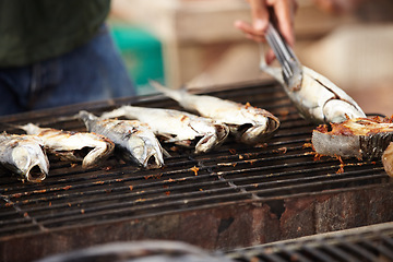 Image showing Fish, food and girll at a street market in Thailand for nutrition or local delicacy during travel closeup. Cuisine, trade and seafood outdoor for purchase or experience of culture and tradition