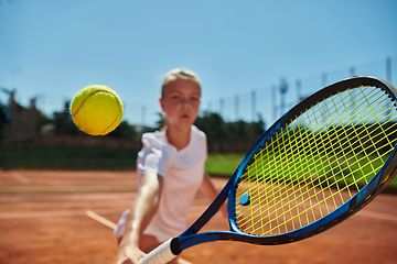 Image showing Close up photo of a young girl showing professional tennis skills in a competitive match on a sunny day, surrounded by the modern aesthetics of a tennis court.